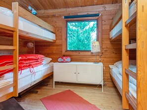 A cabin with bunk beds, a small white dresser, and a window with a view of trees. - 6 Person Holiday Home in Henne (Henne)