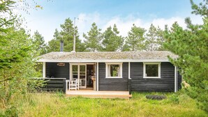 A cabin with a deck, a chimney, and a sign that reads 'Fermat.' - 6 Person Holiday Home in Henne (Henne)