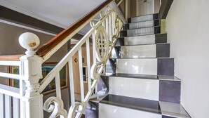 A staircase with white balusters and a wooden handrail, leading to a landing with a door. - OYO Flagship 90886 Sunset View Homestay (Mojokerto)