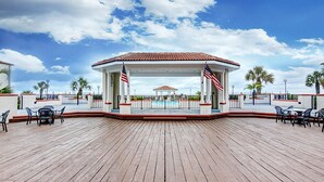 Een overdekt buitengebied met een zwembad, Amerikaanse vlaggen en een houten terras.
