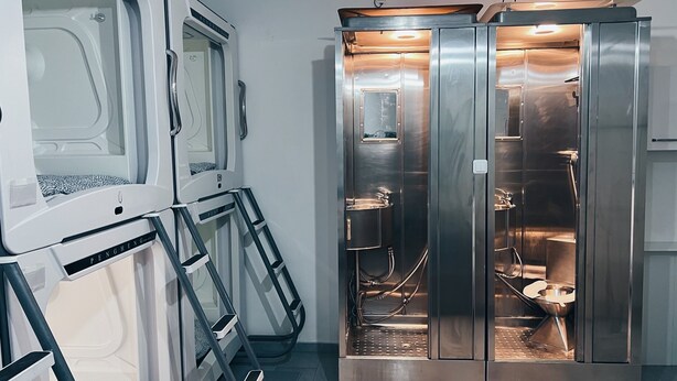 Een moderne badkamer met een douche met glazen wand, een toilet en een wastafel.