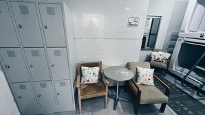 A small seating area with two chairs and a round table, a 'No Smoking' sign, and a kitchenette.
