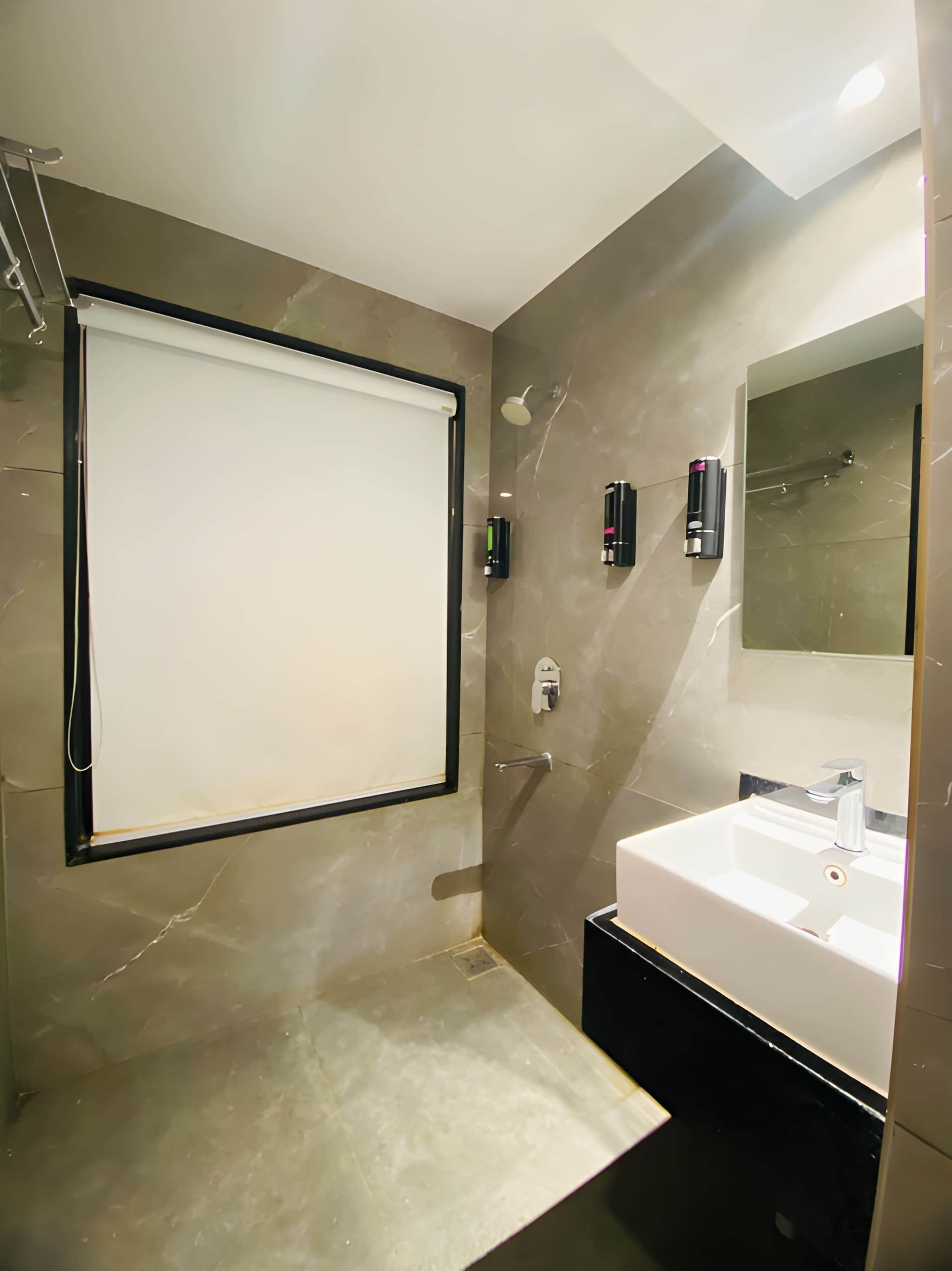 Une salle de bain moderne avec un grand miroir, un lavabo et une douche.