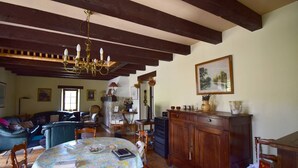 Un accogliente soggiorno con tavolo da pranzo, mobili in legno e un lampadario.
