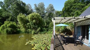 A wooden deck with outdoor seating and a pergola providing shade.