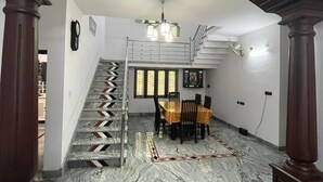 Una escalera en zigzag conduce a un comedor con mesa y sillas.