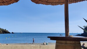 Une plage avec des structures en bois, un ciel dégagé et la mer.