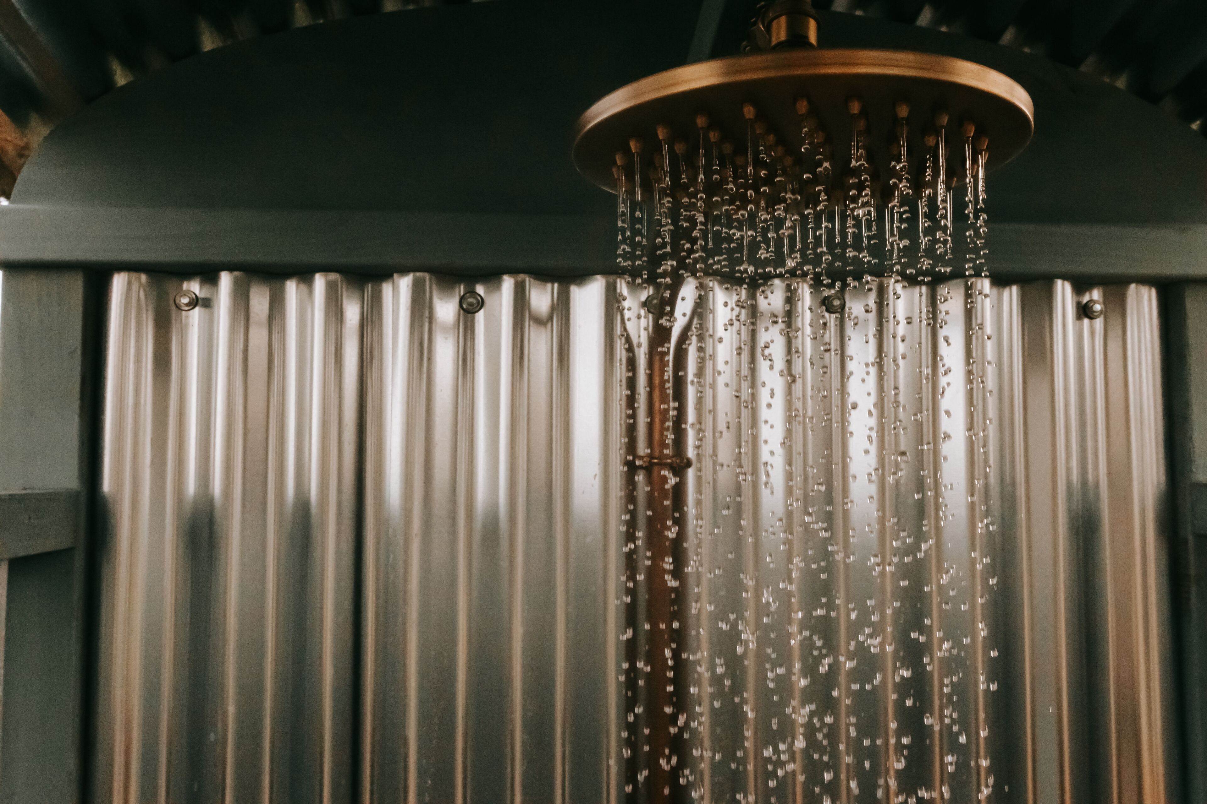 Een douche met meerdere stralen en een metalen gordijn.