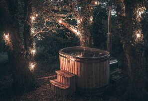 A hot tub in a forested area with wooden steps leading up to it. - Silverlock’s Hide - Off grid romantic hideaway with private wood fired hot tub  (Plymouth)