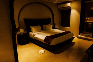 Una habitación de hotel con una cama grande, una mesita de noche y una ventana.