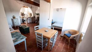 A compact living space with a dining area, a small kitchen, and a sleeping area. - Medieval house - next to Château (Durban-Corbières)
