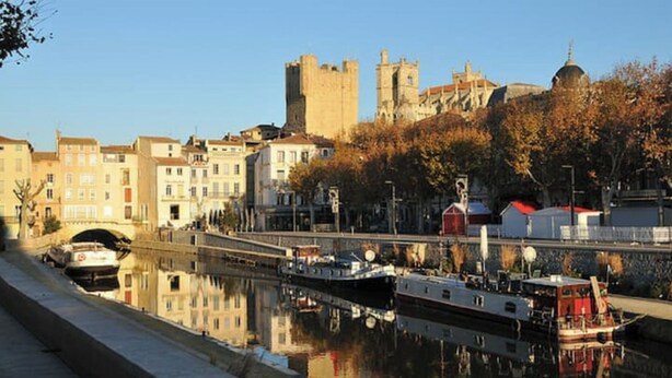 A canal with boats, a bridge, and historic buildings including a castle. - Medieval house - next to Château (Durban-Corbières)