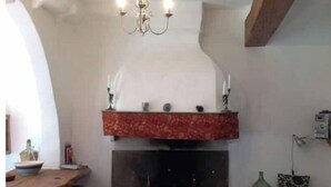 A cozy living room with a fireplace, wooden furniture, and a chandelier. - Medieval house - next to Château (Durban-Corbières)