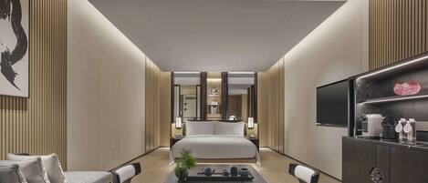 Une chambre d’hôtel moderne dotée d’un grand lit, d’un coin repas avec une table et des chaises, d’une télévision et d’un mini-bar.