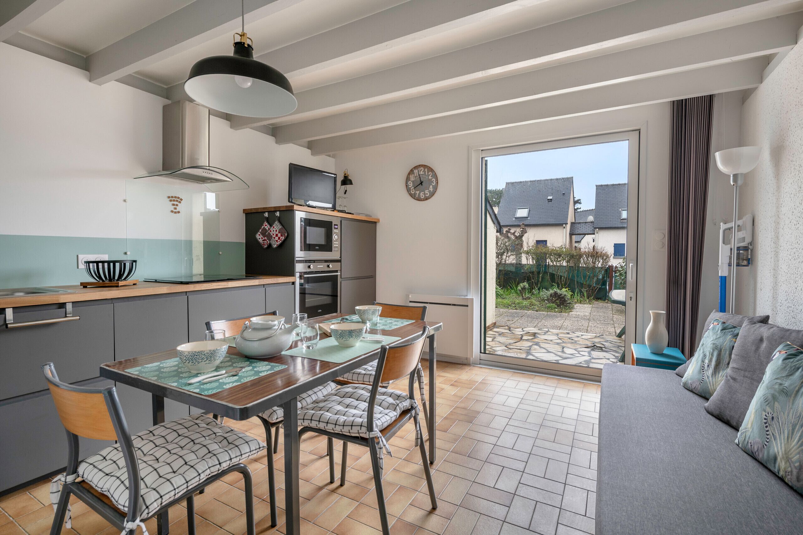 Una cocina moderna con comedor, sofá y vistas al exterior.