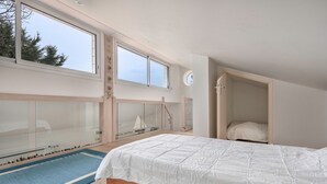 Un dormitorio con una cama grande, una ventana y un armario empotrado.
