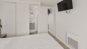 A modern hotel room with a bed, a television mounted on the wall, and a wardrobe. - Pretty Chalet for 6- Estate with swimming pool (Bretignolles-sur-Mer)