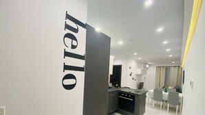 A modern kitchen with a built-in oven and a dining area with a table and chairs. - Central Cozy Located Apt (Msida)