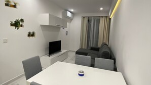A modern, compact living space with a dining area, a kitchenette, and a seating area. - Central Cozy Located Apt (Msida)