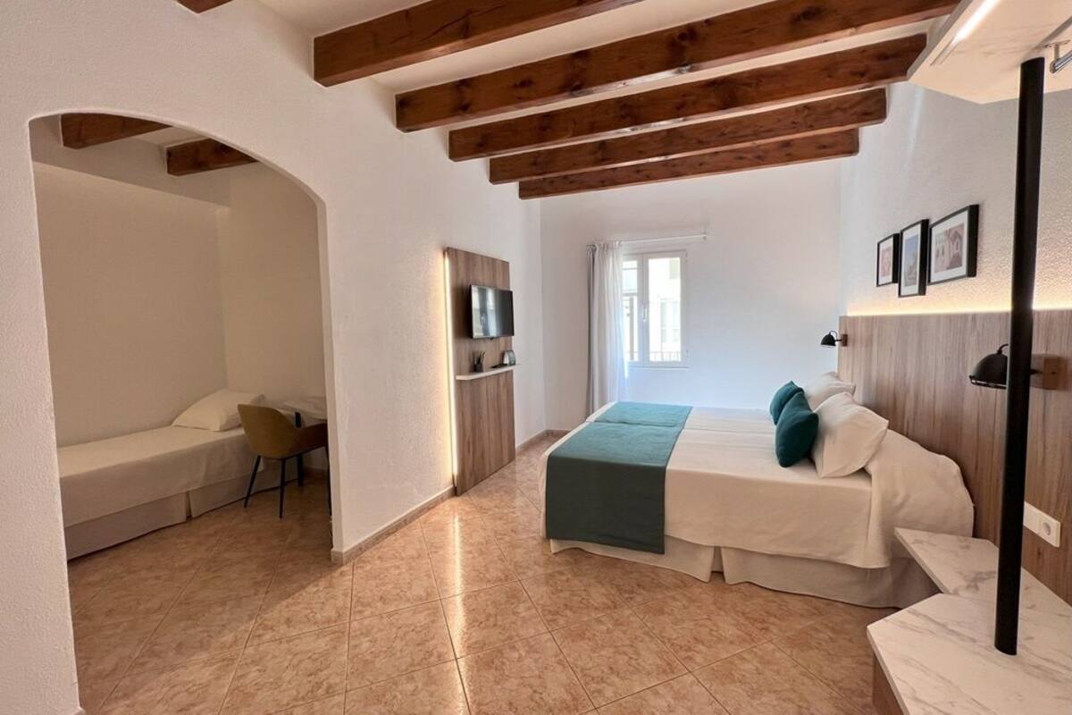 Une chambre à coucher avec un lit, une chaise, un bureau et un téléviseur.