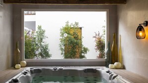A modern bathroom with a large window, a bathtub, and decorative bottles. - Hotel Alfons (Ciutadella de Menorca)
