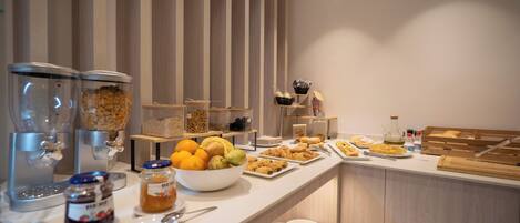 A buffet setup with various food items and condiments.