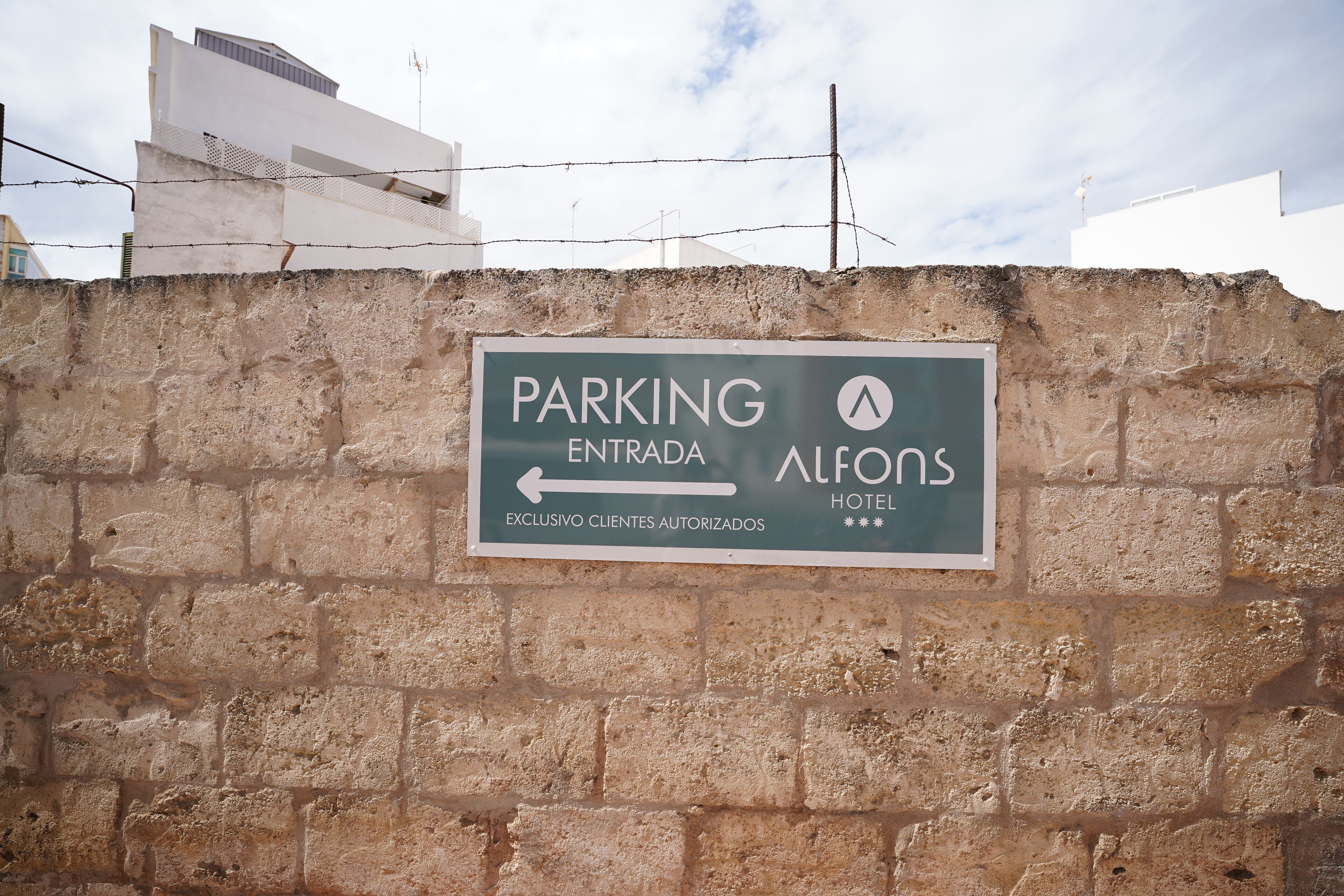 A sign indicating the entrance to the parking area for Alfons Hotel.