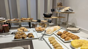 A buffet with various pastries and desserts, including croissants, pastries, and a cake. - Hotel Alfons (Ciutadella de Menorca)