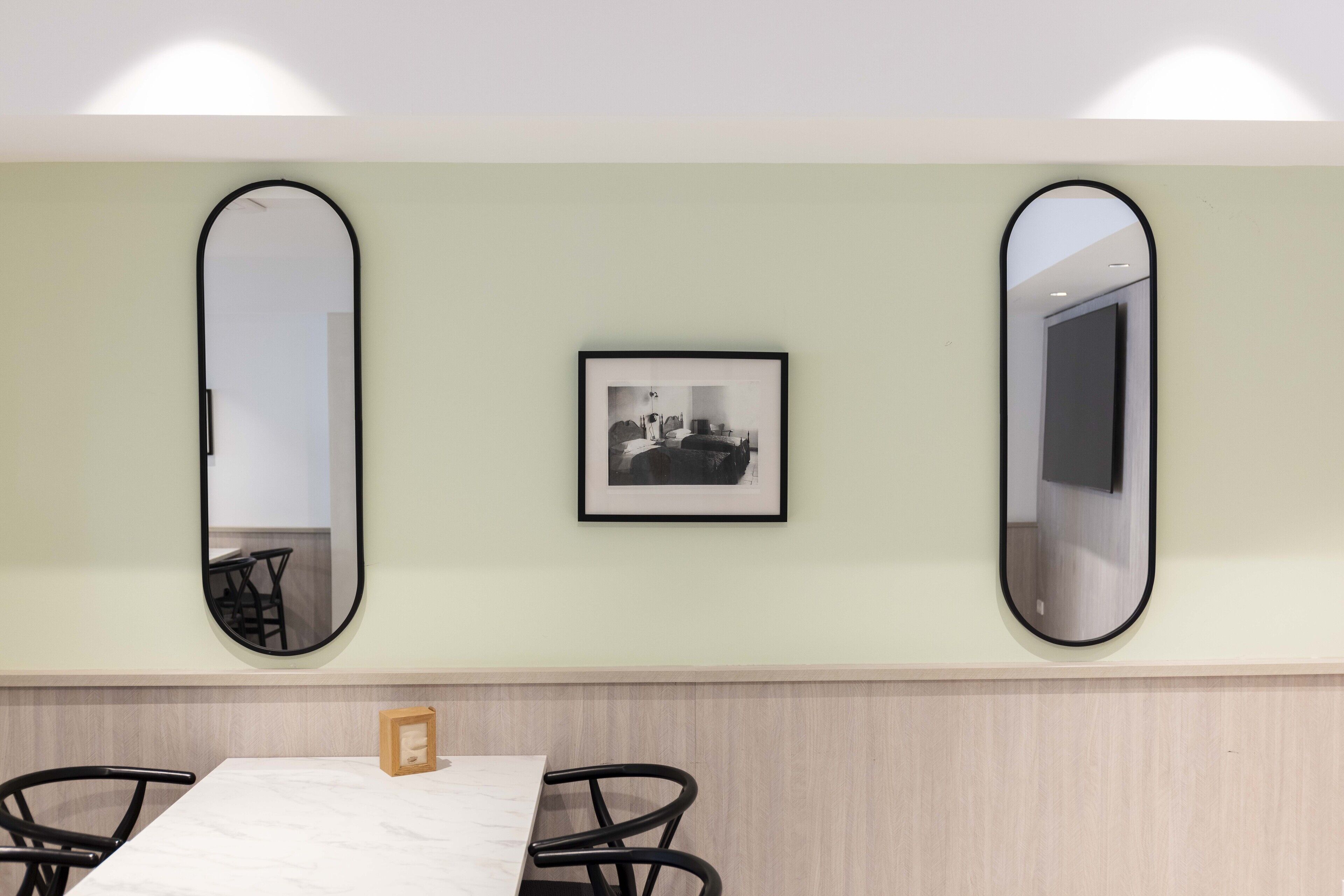 Un comedor con una mesa, sillas y una fotografía enmarcada en la pared.