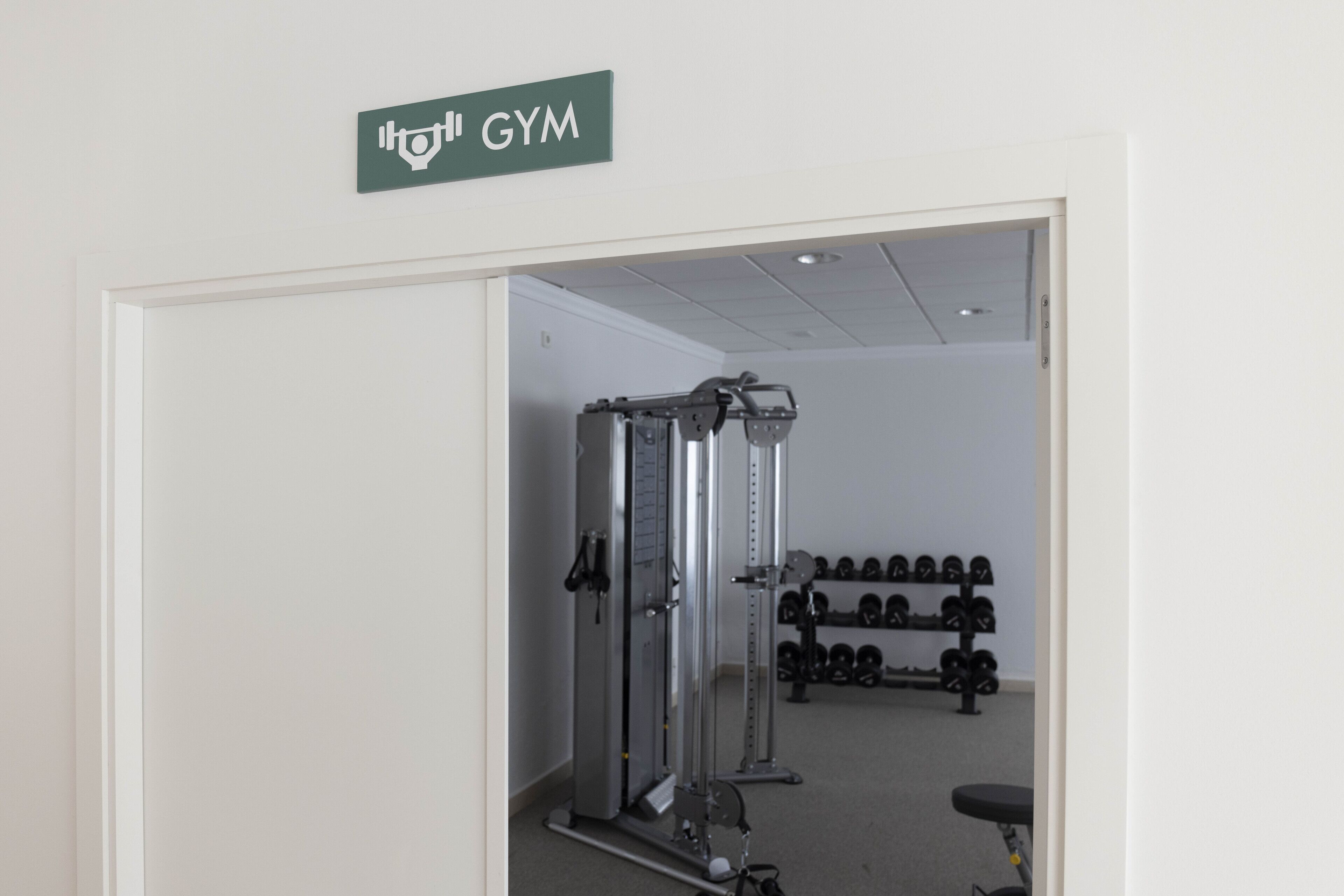 Uma academia com equipamentos de musculação e halteres.