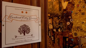 A sign for Central City Genova with contact information and a tree design.