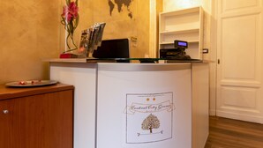 A reception desk with a world map, a flower vase, and a computer monitor. - CENTRAL CITY (Genoa)
