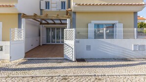 A two-story house with a covered patio, a gated entrance, and a cobblestone driveway. - Villa with parking in the center of the village by AlgarveManta (10V3) (Manta Rota)
