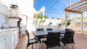 An outdoor patio with a table and chairs, a grill, and potted plants. - Villa with parking in the center of the village by AlgarveManta (10V3) (Manta Rota)