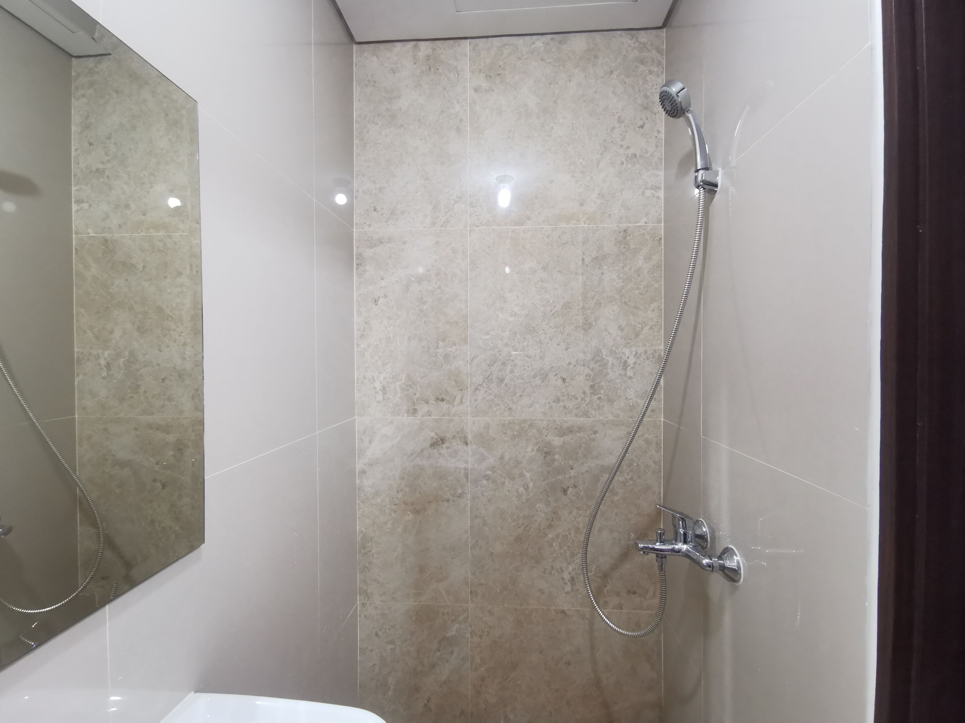 A bathroom with a shower, a sink, and a mirror.