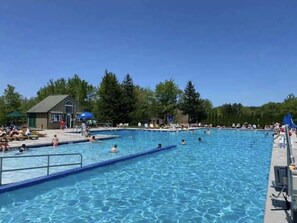 A large outdoor swimming pool with multiple lanes, surrounded by trees and a small building. - Family & Pet friendly in the Poconos! Spa room on property for ultimate relaxing (Tobyhanna)
