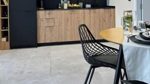 A modern kitchen with dark cabinetry, a microwave, and a wooden countertop. There is a dining area with a table and chairs. - NordiK 2 - Beautiful apartment close to science (València)