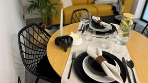 A dining table set with black and white plates, cutlery, and a glass of water. - NordiK 2 - Beautiful apartment close to science (València)