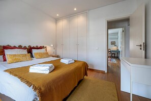 Une chambre avec un grand lit, un bureau et une armoire.