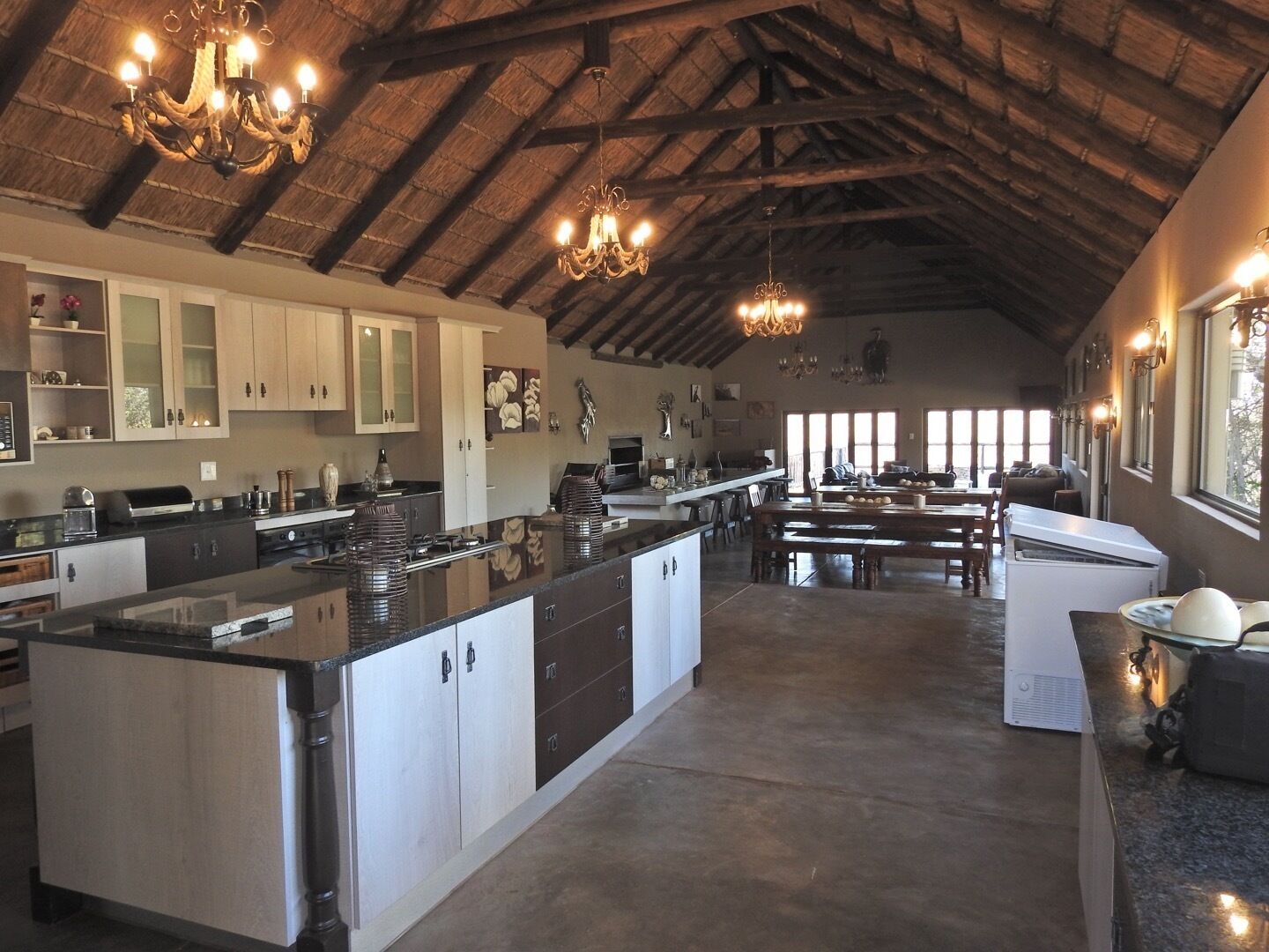 A spacious kitchen with a large island, wooden cabinets, and a vaulted ceiling.