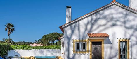 Una casa con piscina, una puerta y ventanas.