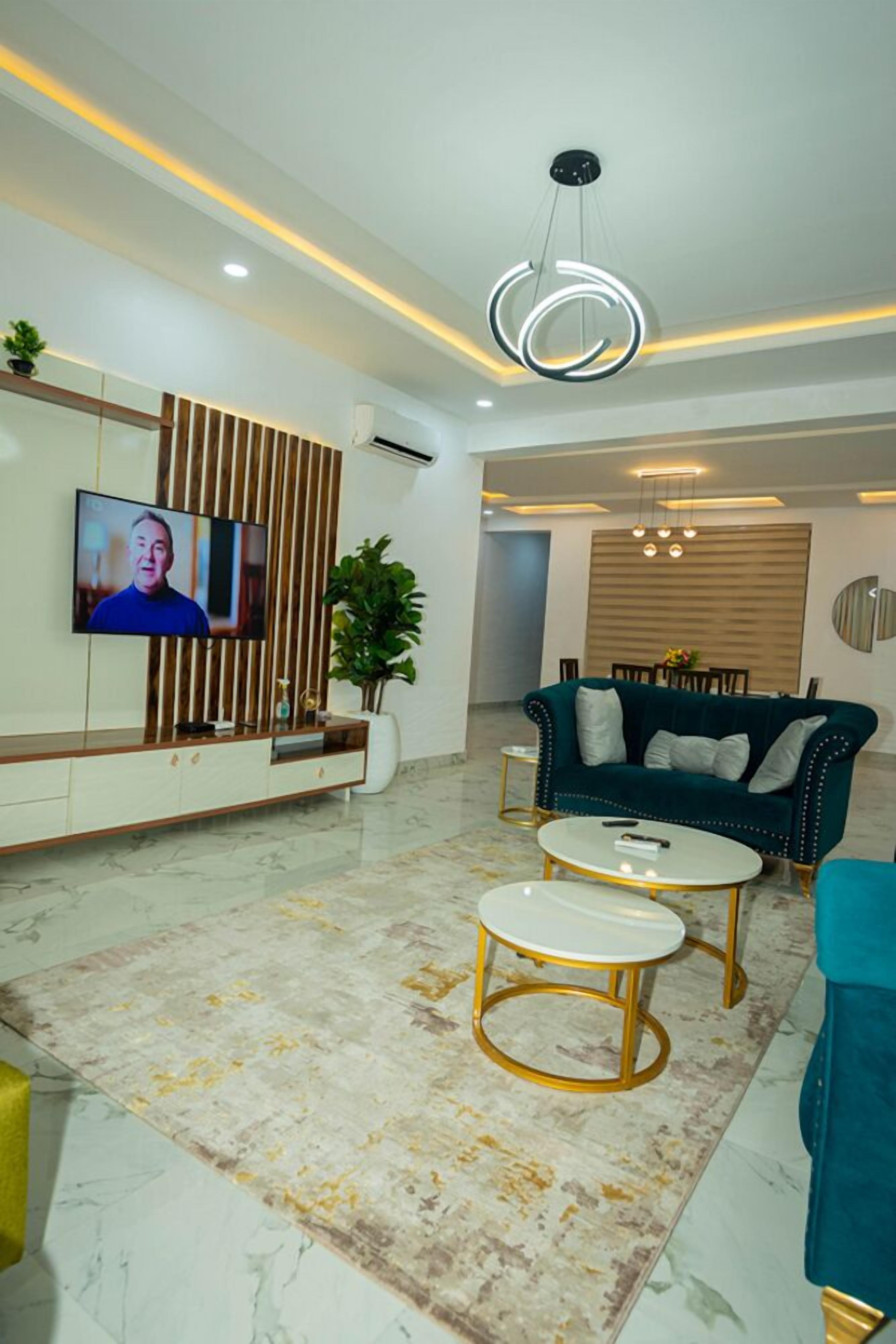 A modern living room with a TV, sofa, coffee table, and decorative plants.