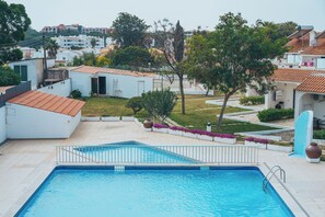 Una piscina al aire libre de temporada, sombrillas, tumbonas