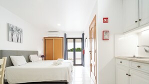A hotel room with a bed, a desk, a chair, a window, and a door. - Apartamentos Vale de Carros by Umbral (Albufeira)
