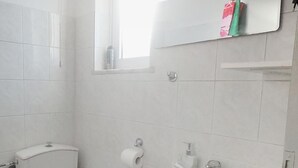 A bathroom with a toilet, sink, and a window above the sink. - Lefteris Insta-worthy Studio With Balcony (Rhodes)