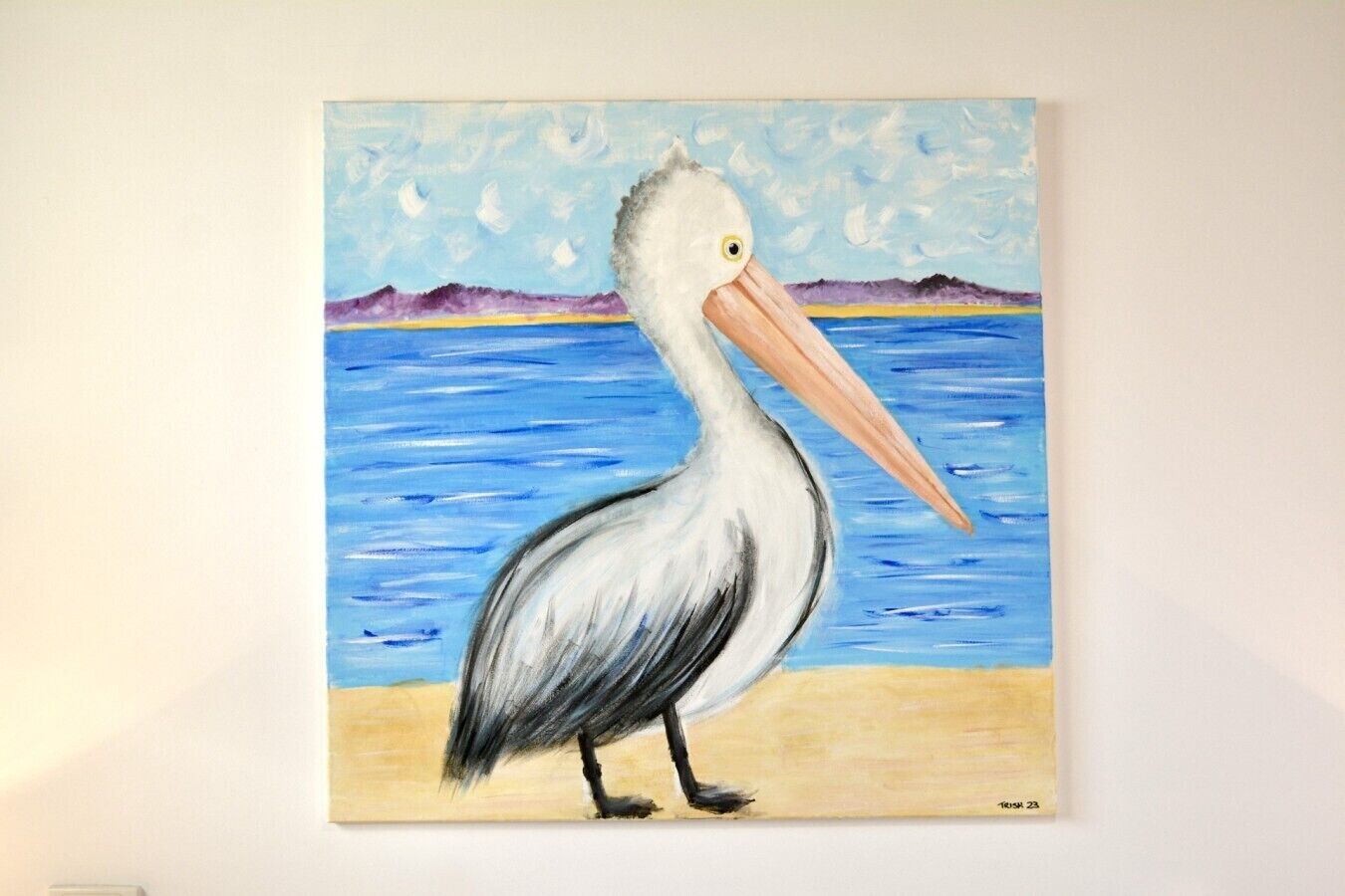 Een schilderij van een pelikaan op het strand.