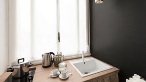 Una cocina moderna con un ventanal grande, un lavamanos, una tetera y una olla sobre la encimera.