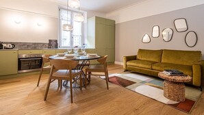 Una cocina moderna con una mesa de comedor y sillas, un sofá verde y una mesa de centro.