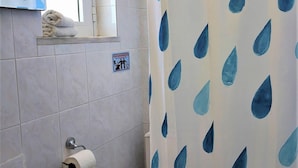 A bathroom with a sink, toilet, and shower curtain with a blue leaf pattern. - Lefteris Insta-worthy Studio With Garden View (Rhodes)