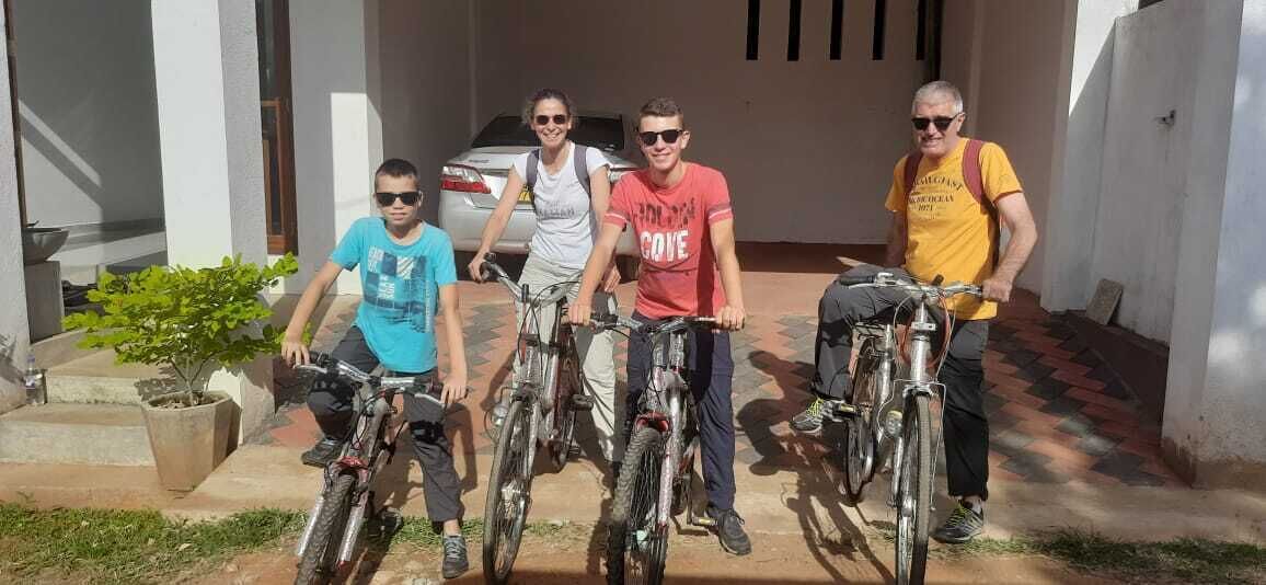 Four people standing in front of a building with bicycles.